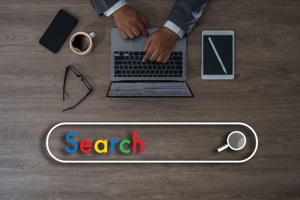 Man werkt op laptop met zoekbalk en Google-stijl ‘Search’-tekst in beeld